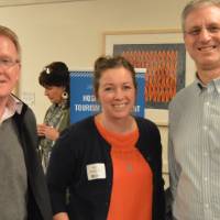 Three alumni pose for a photo at the Academic Major Fair.